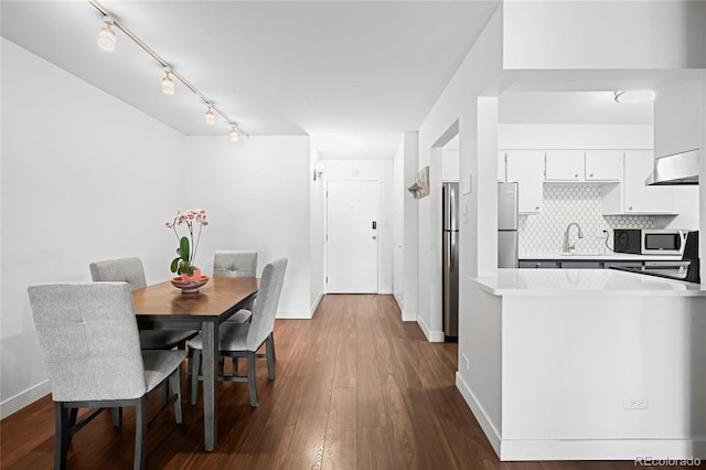 dining space with dark wood-style floors and baseboards