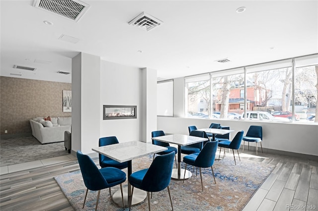 dining space with wood tiled floor, visible vents, and baseboards