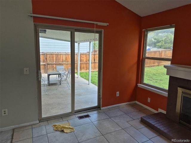 16094 E Exposition Dr, Aurora, CO 80017 - doorway to outside with baseboards, tile patterned flooring, vaulted ceiling, and a glass covered fireplace