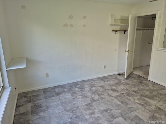 16094 E Exposition Dr, Aurora, CO 80017 - unfurnished bedroom with baseboards, a closet, and stone finish flooring