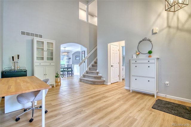 5532 S Valdai Way, Aurora, CO 80015 - office featuring arched walkways, a towering ceiling, light wood finished floors, baseboards, and a chandelier