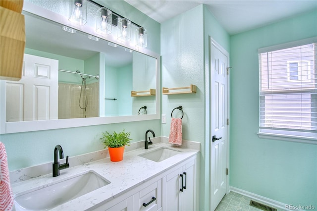 5532 S Valdai Way, Aurora, CO 80015 - bathroom featuring plenty of natural light, double vanity, a shower, and baseboards