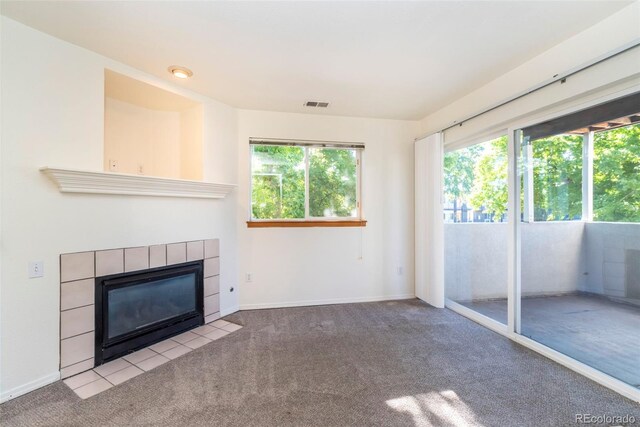 unfurnished living room with a tile fireplace and light colored carpet