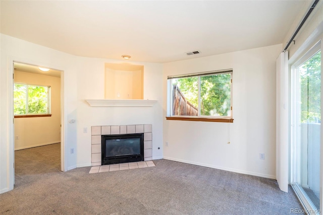 2850 Aurora Ave Unit 112, Boulder, CO 80303 - unfurnished living room featuring a tiled fireplace, plenty of natural light, and carpet floors