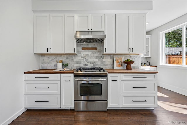 kitchen with gas range, under cabinet range hood, butcher block counters, baseboards, and tasteful backsplash