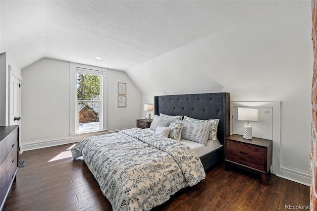 bedroom with dark wood-style floors, vaulted ceiling, and baseboards