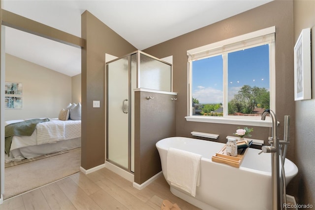 12814 Forest Cir, Thornton, CO 80241 - full bathroom featuring wood finished floors, a shower stall, a soaking tub, lofted ceiling, and baseboards