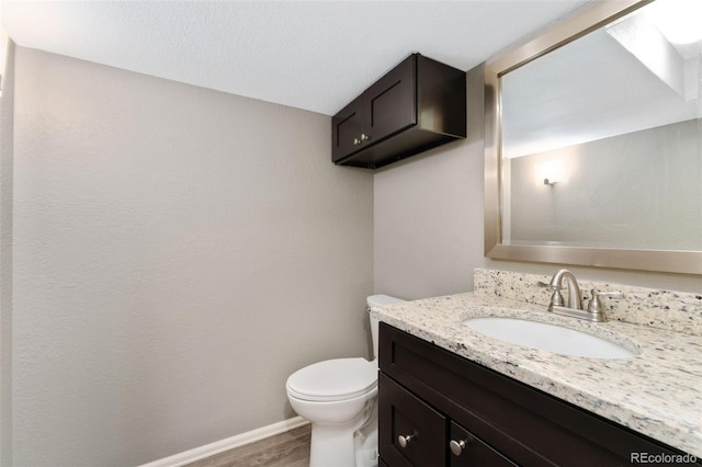 12814 Forest Cir, Thornton, CO 80241 - bathroom featuring toilet, vanity, wood finished floors, and baseboards