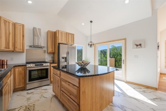 kitchen featuring a center island, vaulted ceiling, wall chimney exhaust hood, appliances with stainless steel finishes, and decorative light fixtures