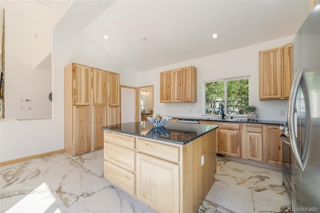 kitchen featuring dark stone counters, a center island, vaulted ceiling, appliances with stainless steel finishes, and light brown cabinetry