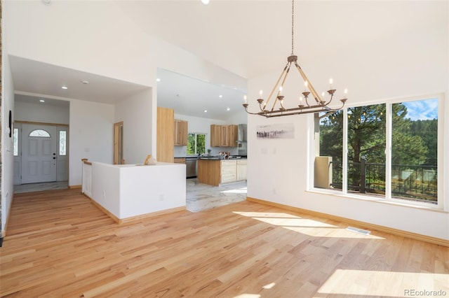 kitchen featuring hanging light fixtures, high vaulted ceiling, dishwasher, an inviting chandelier, and light wood-type flooring