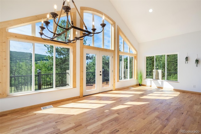 unfurnished sunroom featuring lofted ceiling, french doors, and a notable chandelier