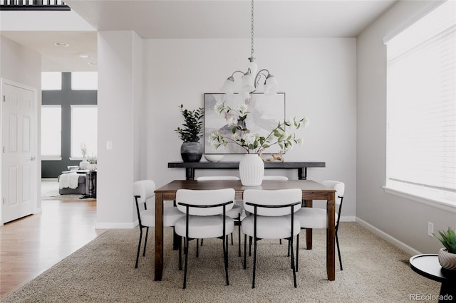 dining area with wood finished floors, baseboards, and a chandelier