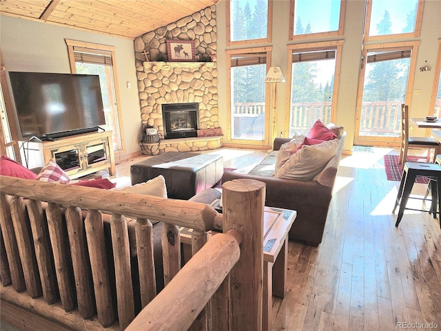 living room with high vaulted ceiling, wood-type flooring, a fireplace, and wood ceiling