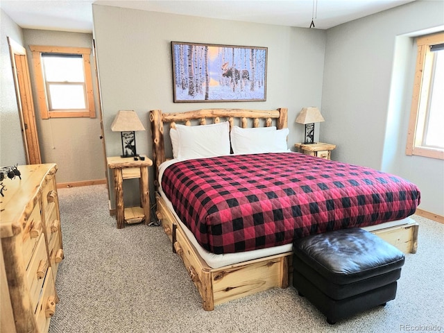 bedroom featuring carpet floors, multiple windows, and baseboards