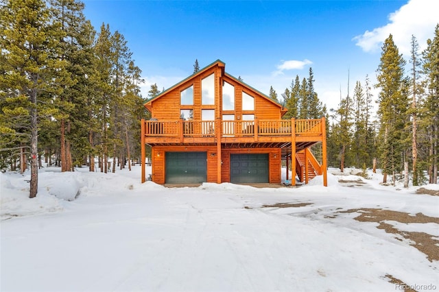 exterior space with log veneer siding, a deck, an attached garage, and stairs