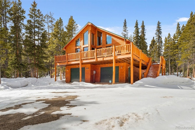 view of front of property with an attached garage, stairs, and a wooden deck