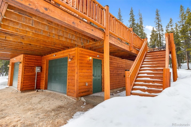 exterior space with faux log siding and an attached garage