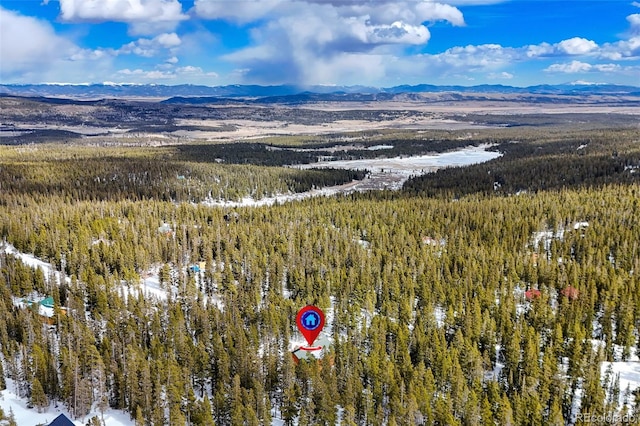 drone / aerial view with a mountain view and a view of trees