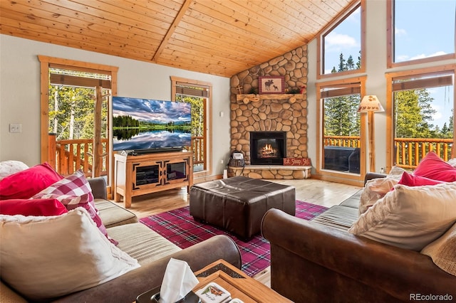 living area featuring a stone fireplace, wood ceiling, wood finished floors, and high vaulted ceiling