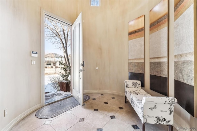 doorway to outside with baseboards and tile patterned floors