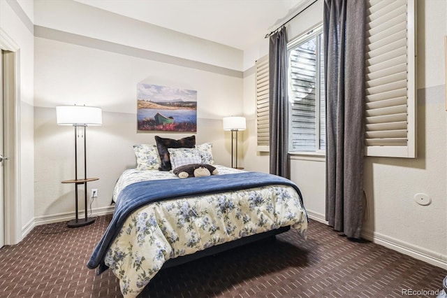 bedroom with baseboards and dark colored carpet