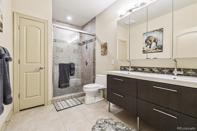 bathroom with toilet, a shower stall, vanity, and tile patterned floors