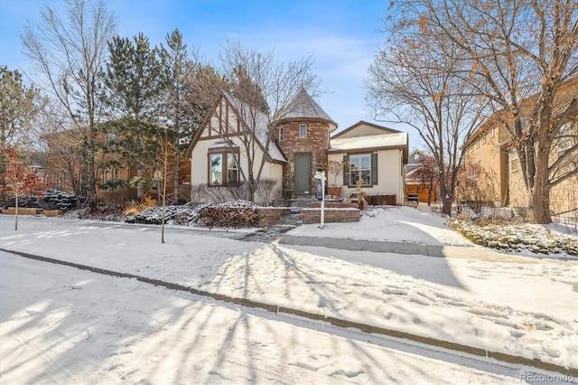 tudor-style house featuring stucco siding