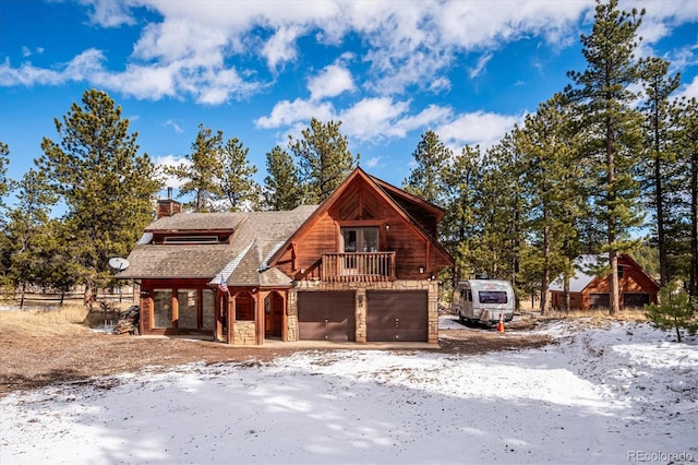 rustic home featuring a garage, a balcony, stone siding, a chimney, and roof with shingles