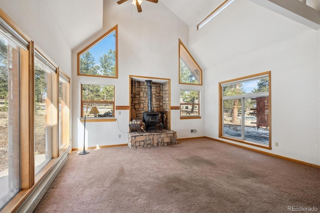 unfurnished living room featuring carpet floors, plenty of natural light, high vaulted ceiling, and a wood stove