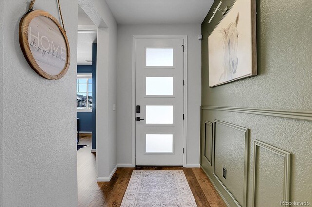 4040 Eaton Park St, Aurora, CO 80019 - entryway with wood finished floors, a textured wall, and baseboards