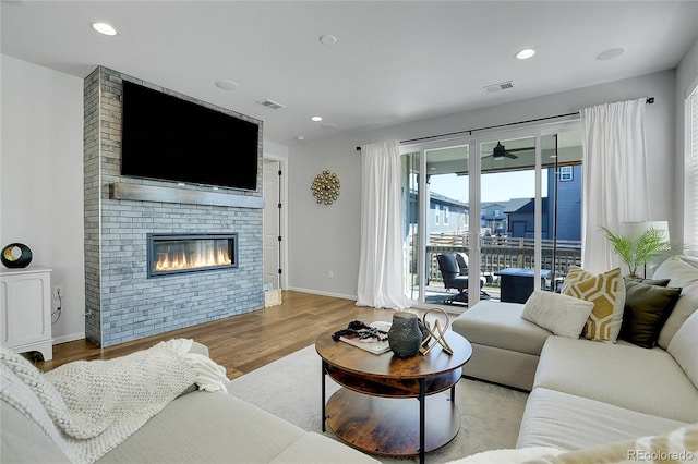 4040 Eaton Park St, Aurora, CO 80019 - living room featuring wood finished floors, baseboards, a large fireplace, and recessed lighting