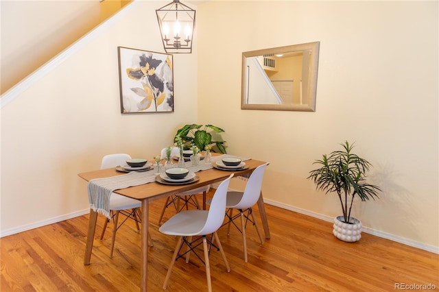 dining space featuring hardwood / wood-style floors and a notable chandelier