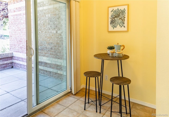 doorway to outside with light tile patterned floors