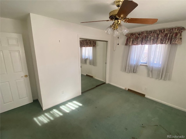 empty room featuring dark colored carpet and ceiling fan