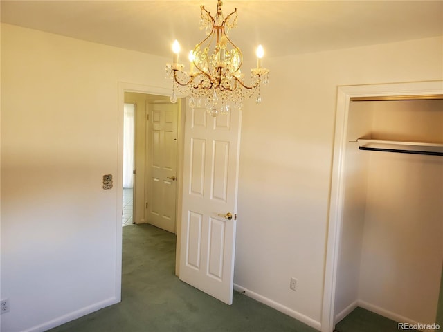 interior space featuring dark carpet, a closet, and a notable chandelier