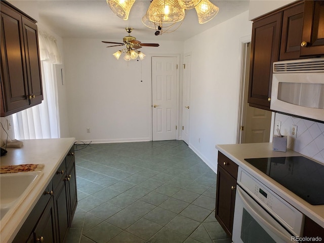 kitchen featuring dark brown cabinetry, sink, white appliances, and decorative backsplash