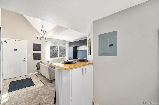 kitchen with light carpet, wood counters, vaulted ceiling, pendant lighting, and electric panel