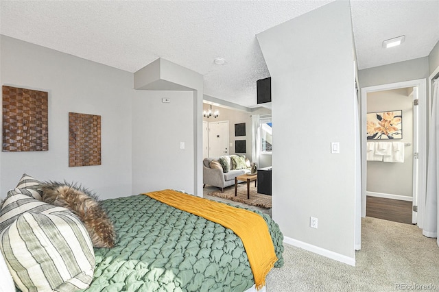 carpeted bedroom featuring a textured ceiling and an inviting chandelier