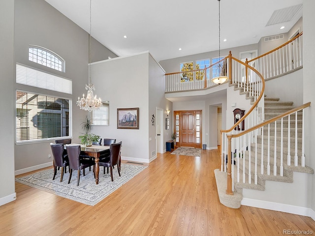8312 S Peninsula Dr, Littleton, CO 80120 - entrance foyer with a high ceiling, a chandelier, stairs, baseboards, and wood finished floors