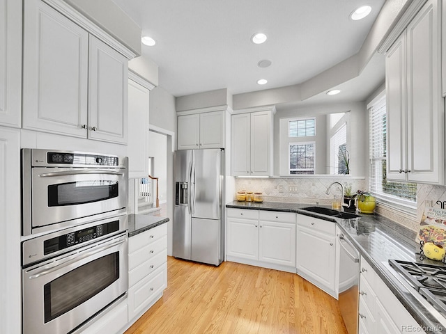 8312 S Peninsula Dr, Littleton, CO 80120 - kitchen with appliances with stainless steel finishes, a sink, white cabinetry, and recessed lighting