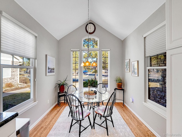 8312 S Peninsula Dr, Littleton, CO 80120 - dining room featuring light wood-type flooring, vaulted ceiling, healthy amount of natural light, and baseboards