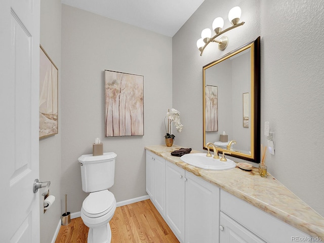 8312 S Peninsula Dr, Littleton, CO 80120 - bathroom with wood finished floors, vanity, toilet, and baseboards