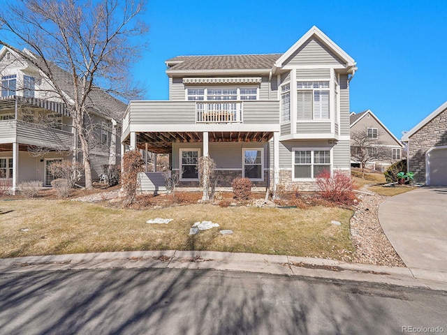 8312 S Peninsula Dr, Littleton, CO 80120 - view of front facade with a balcony, stone siding, and a front lawn
