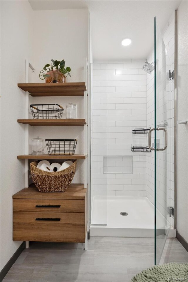 bathroom featuring a shower with door, vanity, and hardwood / wood-style flooring