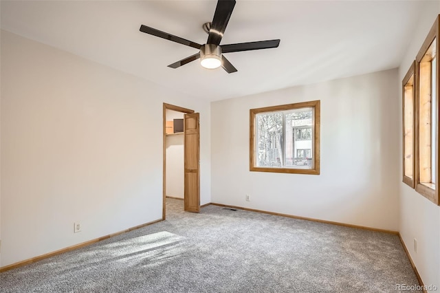 spare room with light carpet, ceiling fan, and baseboards