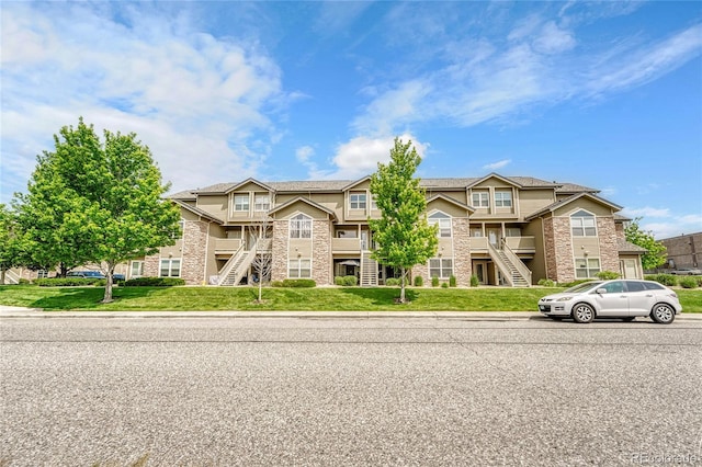 3261 S Waco Ct Unit C, Aurora, CO 80013 - view of front of house featuring stairway, stone siding, and a front yard