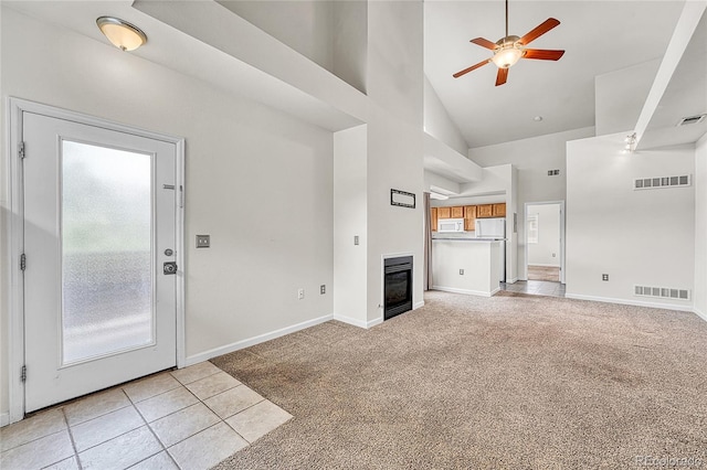 3261 S Waco Ct Unit C, Aurora, CO 80013 - unfurnished living room with high vaulted ceiling, ceiling fan, light colored carpet, a glass covered fireplace, and baseboards