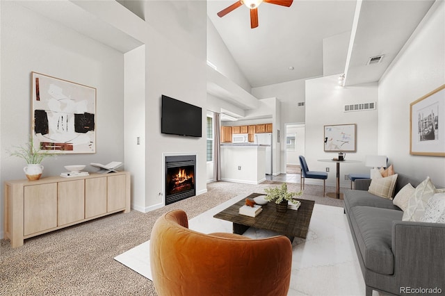 3261 S Waco Ct Unit C, Aurora, CO 80013 - living room with high vaulted ceiling, a ceiling fan, a warm lit fireplace, light carpet, and baseboards