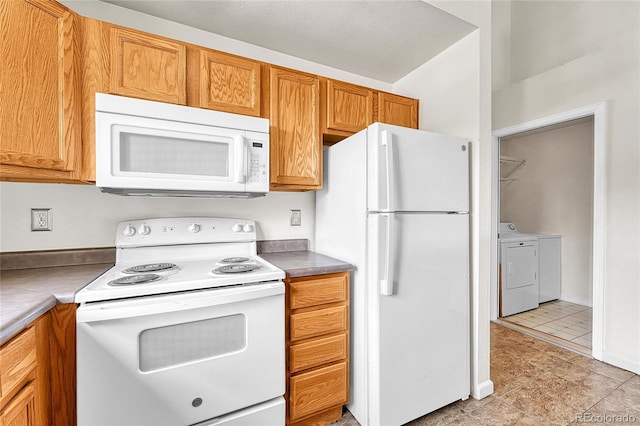 3261 S Waco Ct Unit C, Aurora, CO 80013 - kitchen with white appliances, washing machine and dryer, light tile patterned flooring, and brown cabinetry